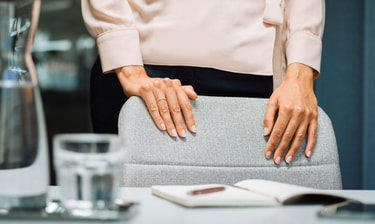 Frau mit Händen auf einem Bürostuhl Femme avec les mains sur une chaise de bureau